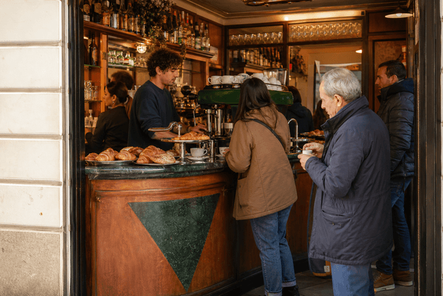 Bancone di un bar italiano indipendente con brioche e macchina espresso durante il servizio del mattino